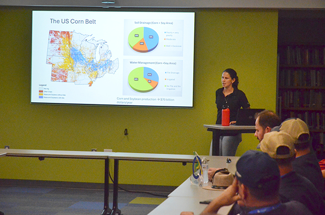 Graduate student Carolina Freitas provides a research overview to the group of visiting farmers.